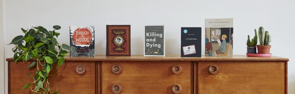 Graphic novels and plants arranged on sideboard