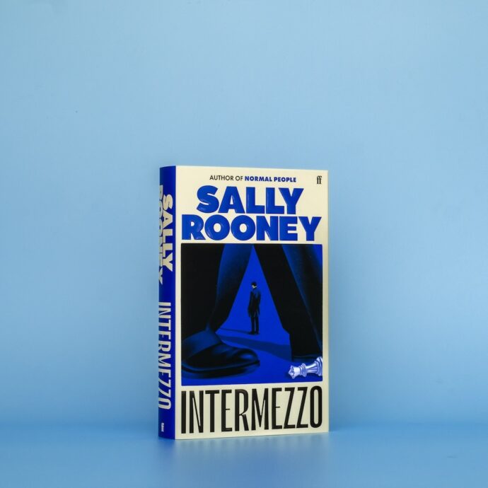 Hardback edition of Sally Rooney's novel Intermezzo on a blue background