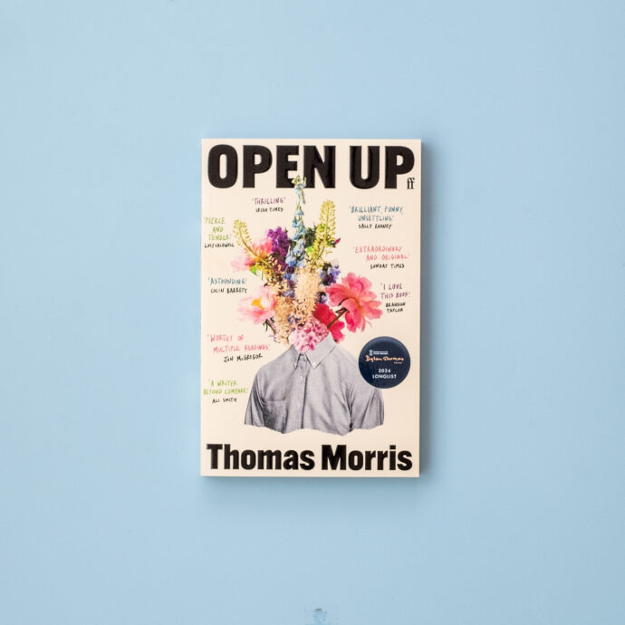 Paperback of Open Up by Thomas Morris on a blue background